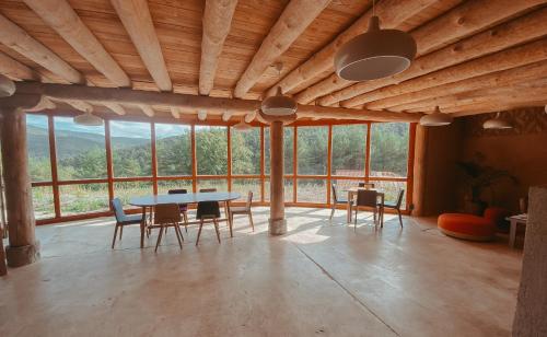 a dining room with a table and chairs and windows at Agotzenea - Alojamiento con encanto en un entorno rural in Zubiri