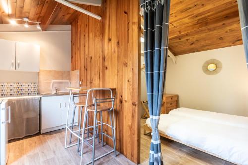 Cette chambre comprend un lit et une cuisine avec des murs en bois. dans l'établissement Frenchyhomes☆Andernos☆6 personnes☆plage et centre, à Andernos-les-Bains