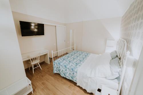 a white bedroom with a bed and a desk at La casa di Achille in Chieti