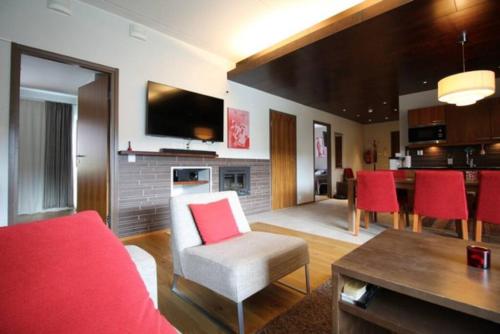 a living room with a red couch and red chairs at Tahko SPA Luxury Suite Orange B5 with Mountain View in Tahkovuori