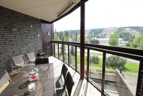 a balcony with a table and chairs and a large window at Tahko SPA Luxury Suite Orange B5 with Mountain View in Tahkovuori