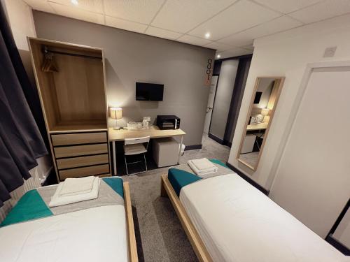 a dorm room with two beds and a desk at CACCO - Contractor Accommodation in Corby