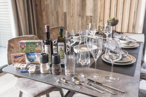 a table with wine bottles and glasses on it at Perfect Lodgings Panorama Hart in Hart im Zillertal