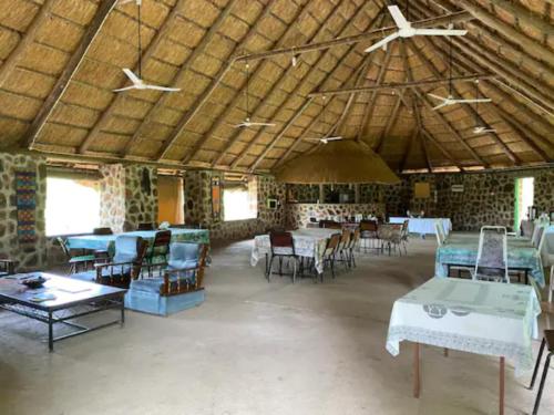 a large room with tables and chairs in a building at Bungalow 3 on this world renowned Eco site 40 minutes from Vic Falls Fully catered stay - 1987 in Victoria Falls