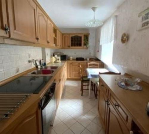 a kitchen with wooden cabinets and a sink and a table at Stadthaus Laucha in Laucha