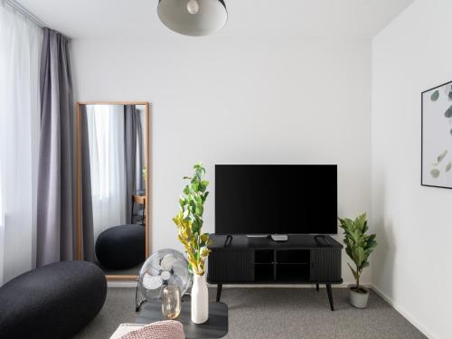 a living room with a flat screen tv on a stand at Limehome Linz Friedrichstraße in Linz