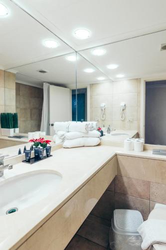a bathroom with two sinks and a large mirror at Almog Haifa Israel Apartments מגדלי חוף הכרמל in Haifa
