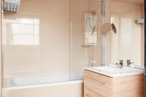a bathroom with a tub and a sink and a shower at Residhome Paris Clamart in Clamart