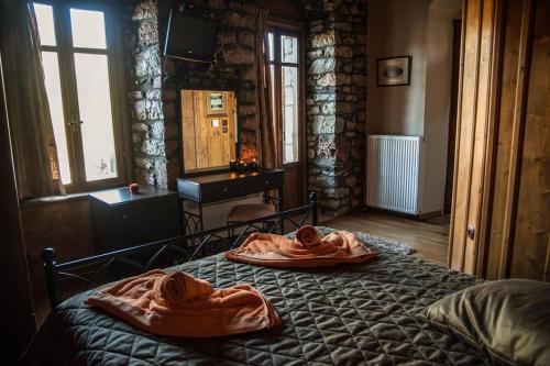 een slaapkamer met een bed en 2 badjassen bij Despotikon Dimitsana Guest house - Ξενώνας Δεσποτικόν Αντωνόπουλου in Dhimitsana