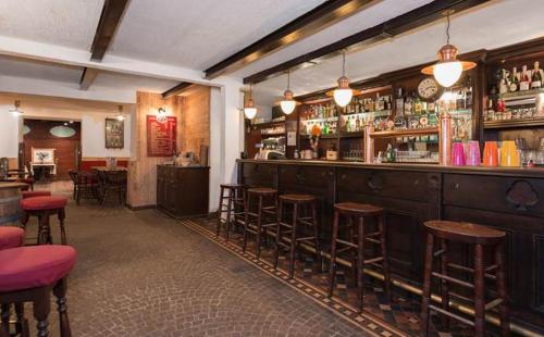 un bar con taburetes de madera en un restaurante en Hotel Sport Cafe, en Sauze dʼOulx