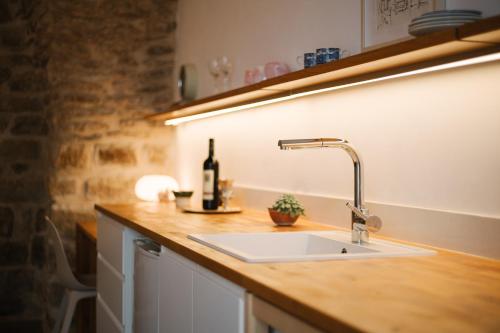 a kitchen counter with a sink and a bottle of wine at Azamra Inn Tzfat in Safed