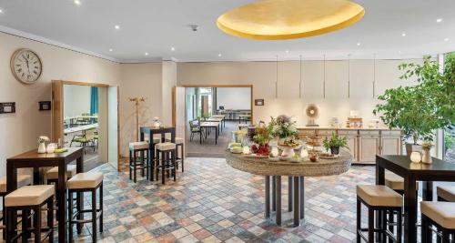 a large room with tables and chairs and a kitchen at Pfalzhotel Asselheim in Asselheim
