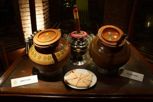 a table with two vases and a plate of food at Faisalabad Serena Hotel in Faisalabad