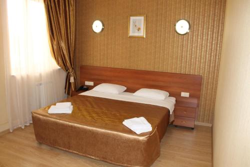 1 dormitorio con 1 cama con 2 toallas en Hotel Mona Lisa, en Nizhny Novgorod