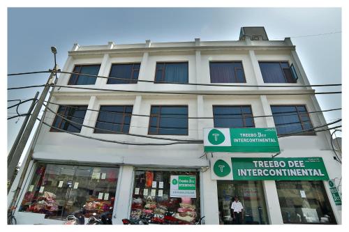 a white building with a tree die intersection at Treebo Trend Dee Intercontinental Amritsar in Amritsar