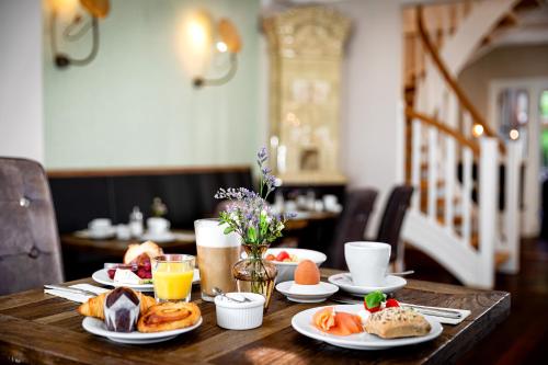 a wooden table with plates of food on it at Alsterblick Boutique Hotel in Hamburg
