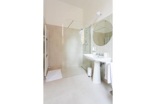 a white bathroom with a sink and a mirror at PALAZZO SABBIONI SUITE DEL CONTE Elegant Suite In Old Monastery City Center in Ferrara