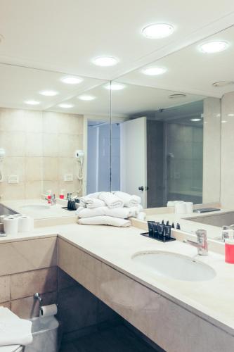 a bathroom with two sinks and a large mirror at Almog Haifa Israel Apartments מגדלי חוף הכרמל in Haifa