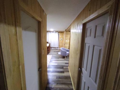 a hallway with a white door and a chair in a room at Cabaña Volcán Hornopirén in Hornopiren