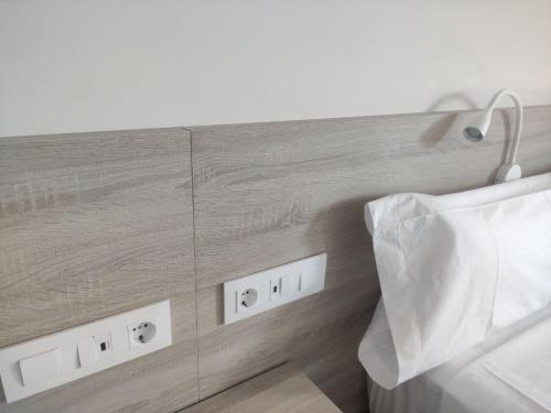 a wooden wall with electrical outlets in a room at Alojamientos Central in Porriño