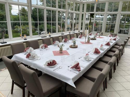 a long dining room with a long table and chairs at Altes Kasino Hotel am See in Neuruppin