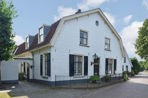 a white house with black windows on a street at La Vie en Roos Amerongen in Amerongen