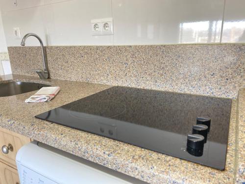 a kitchen with a counter top with a sink and a stove at Benal Beach Rentals in Benalmádena