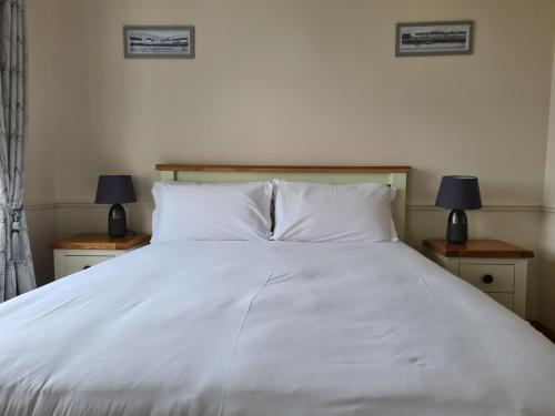
a bed with a white comforter and pillows at Padraicins B&B in Furbo
