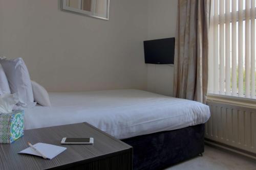 a hotel room with a bed and a table with a table sidx sidx at Parkmore Hotel & Leisure Club, Sure Hotel Collection by BW in Stockton-on-Tees
