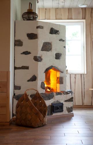 a stone fireplace in a living room with a fire place at Maatilamatkailu Ali-Ketola in Kokemäki