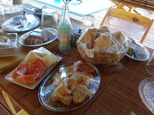 Pousada Obedemar - Taipu de fora, Barra Grande, Ba في بارا غراندي: طاولة خشبية مغطاة بأطباق الطعام والسلال