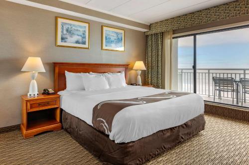 オーシャンシティにあるQuality Inn Boardwalkのベッドとバルコニー付きのホテルルーム