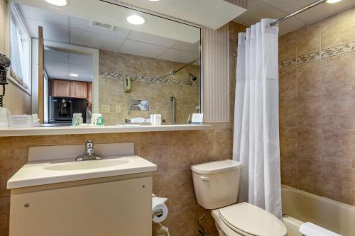 オーシャンシティにあるQuality Inn Boardwalkのトイレ、洗面台、シャワー付きのバスルーム
