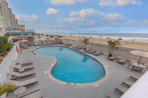 a view of a swimming pool with chairs and a beach at Quality Inn Boardwalk in Ocean City
