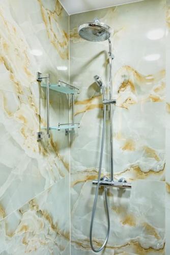 a shower in a bathroom with marble walls at CASA ARTA in Burgas