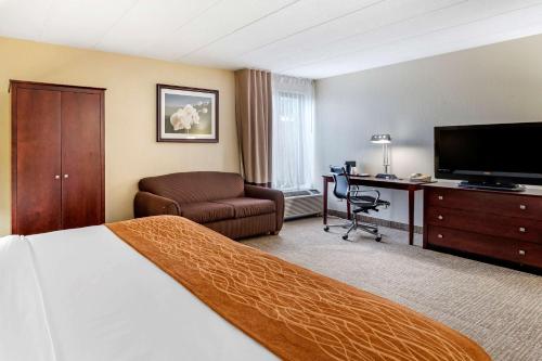 a hotel room with a bed a desk and a television at Comfort Inn Cincinnati Northeast in Mason