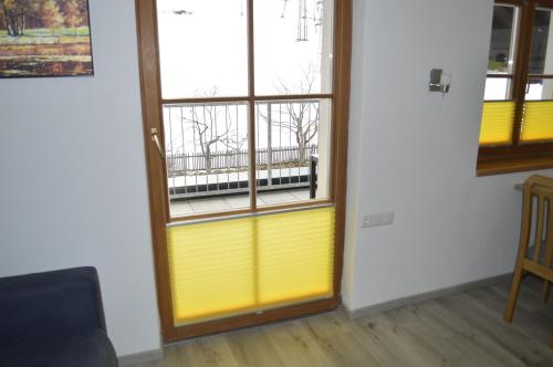a room with a yellow door and a window at Ferienwohnungen Restaurant Pizzeria Langreiter in Embach
