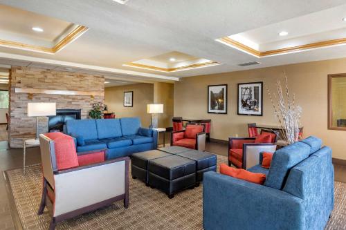 a hotel lobby with blue couches and red chairs at Comfort Inn Evansville-Casper in Evansville
