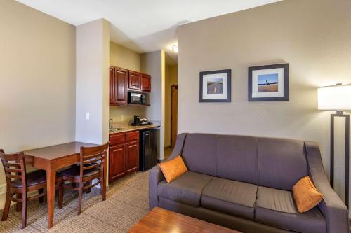 a living room with a couch and a table and a kitchen at Comfort Inn Evansville-Casper in Evansville