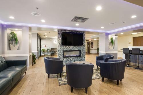 a lobby with couches and a fireplace with a tv at Quality Inn & Suites CVG Airport in Erlanger