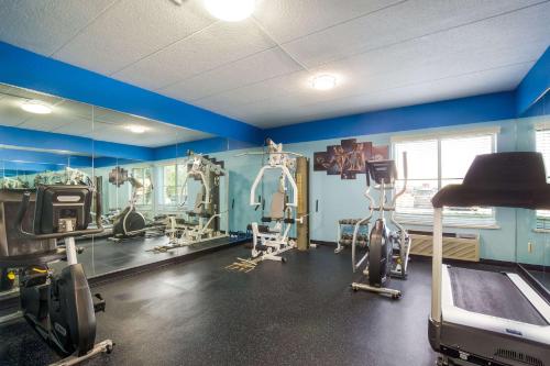a gym with exercise equipment in a room with blue walls at Quality Inn & Suites CVG Airport in Erlanger