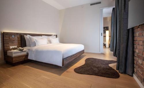 a bedroom with a white bed and a brick wall at Radisson Collection Hotel, Old Mill Belgrade in Belgrade