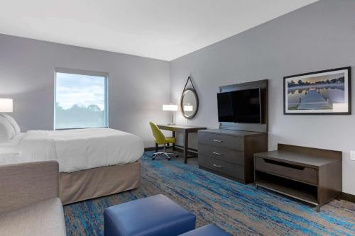 Habitación de hotel con cama y escritorio con TV. en Comfort Inn & Suites en Adrian