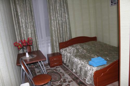 a bedroom with a bed and a desk and a table at Hotel Dinastiya in Nizhny Novgorod
