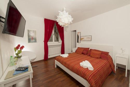 ファブリアーノにあるB&B Del Podestàのベッドルーム1室(赤い掛け布団付きのベッド1台付)