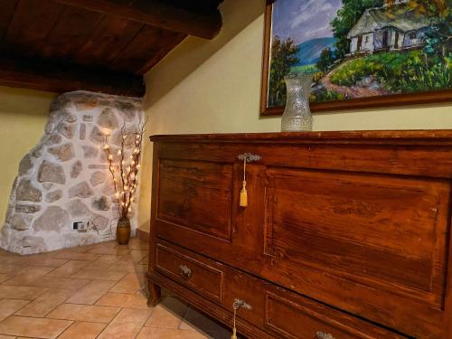a large wooden dresser in a room with a painting at Pacentro Dimora del Castello in Pacentro