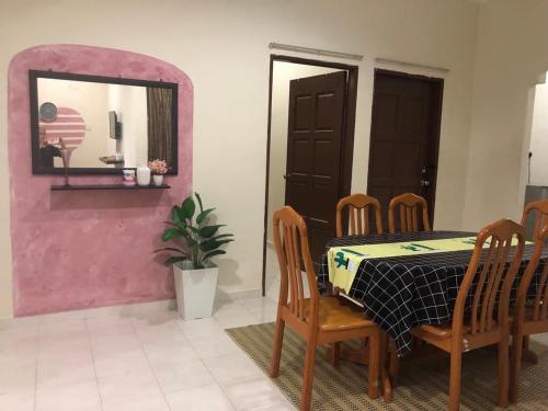 a dining room with a table and chairs and a mirror at HOMESTAY SERI LAZUARDI 3 MACHANG ISLAMIC in Machang