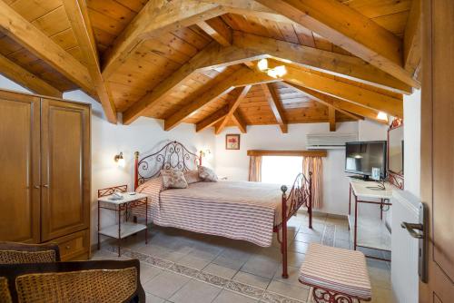 una camera con letto in una stanza con soffitti in legno di Andreolas Luxury Suites a Tsilivi