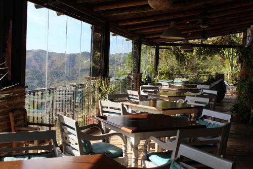 una fila de mesas y sillas en un restaurante en Hotel Rural Los Jarales, en Istán