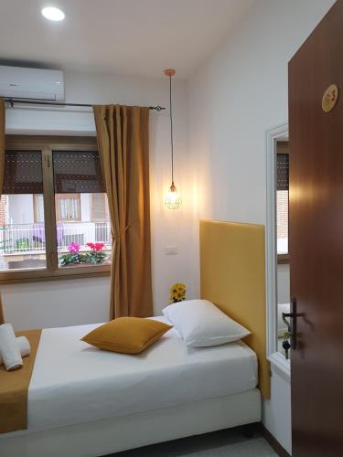 - un lit avec deux oreillers dans une chambre dotée d'une fenêtre dans l'établissement Affittacamere Dianir, à Rome
